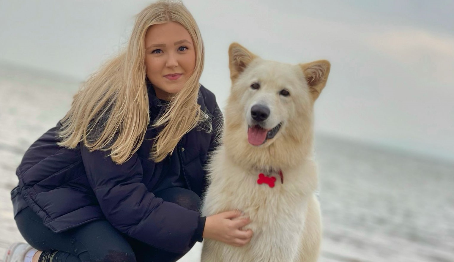 Kerri Simpson holding dog by the beach